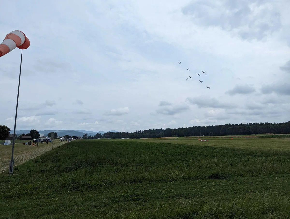 PC7-Flugzeuge fliegen als Schweizerkreuz-Formation über Fehraltorf.